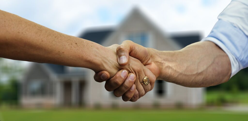 Shaking hands in front of house - DTCI Importance of Perfectly Worded Risk Transfer Provisions